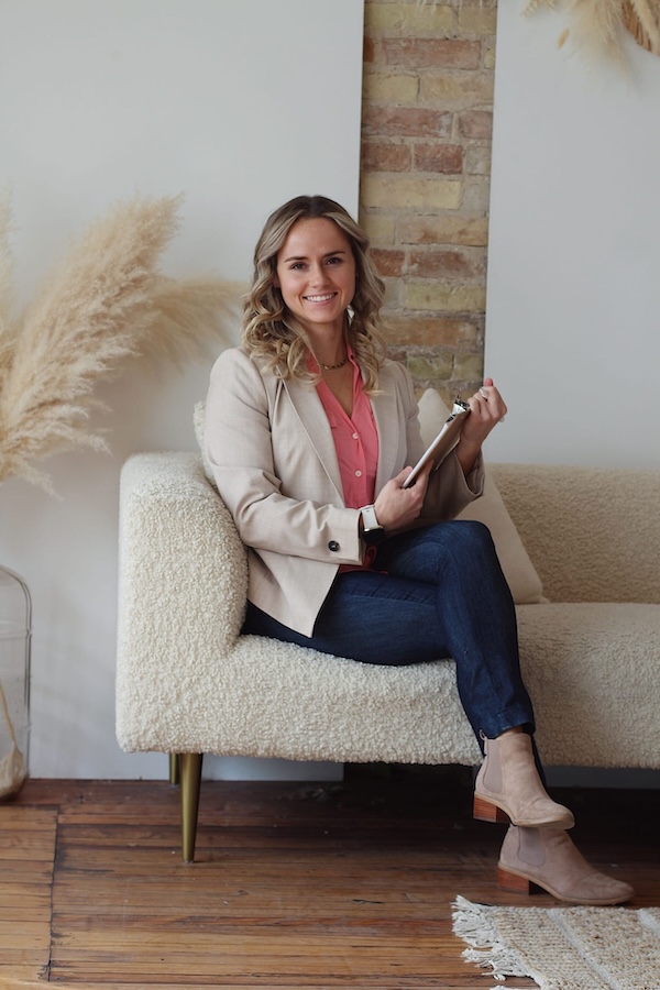 Mariah on a couch holding a clipboard